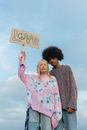 Woman in Pink Sweater Holding a Cardboard