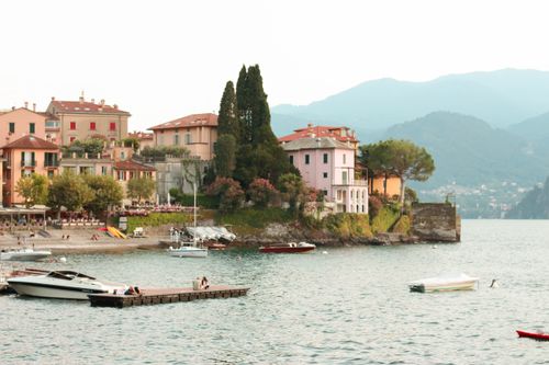 Free Charming lakeside town in Lake Como with boats and mountains in the backdrop. Stock Photo