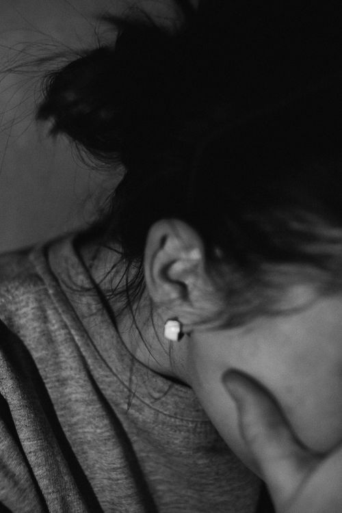 Free Black and white close-up of a woman with hand on face, wearing an earring. Stock Photo