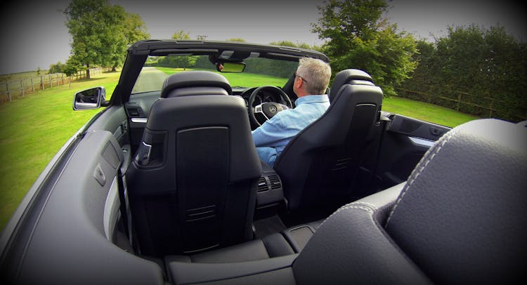 Man In Blue Dress Shirt Driving Convertible Car During Daytime