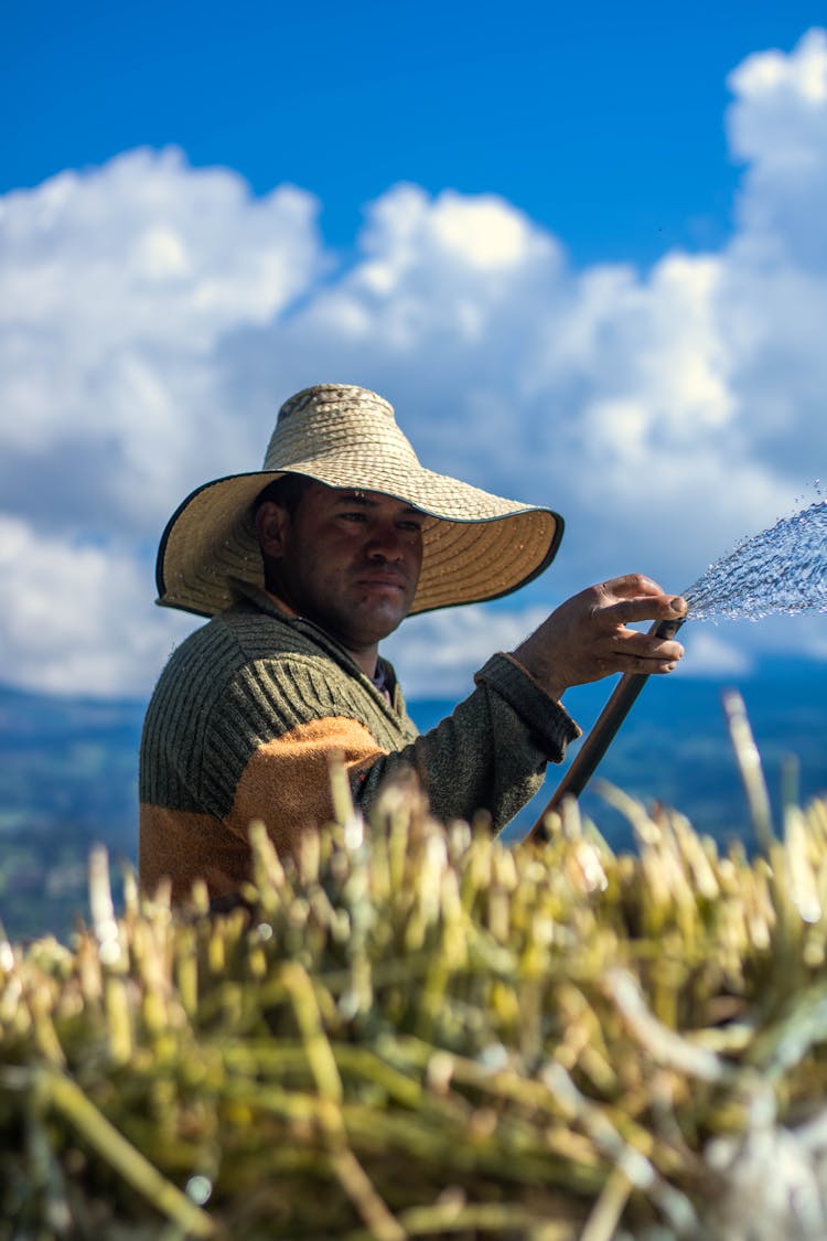 A Gardener Holding A Watering Hose