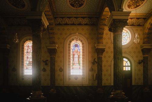 Free Elegant church interior with stained glass windows and ornate decor, highlighting religious art. Stock Photo