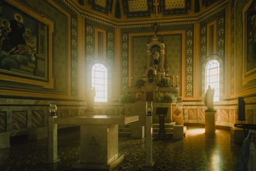 Free Peaceful interior view of a baroque church with an altar, religious statues, and sunlight streaming through windows. Stock Photo