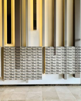 Contemporary mailbox wall featuring numbered slots in a residential building lobby.