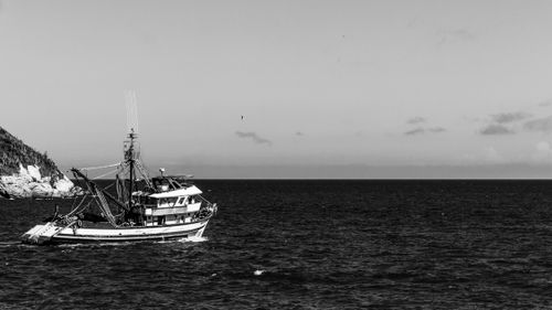 Free A monochrome photo of a fishing boat cruising off the coast of Saquarema, Brazil. Stock Photo