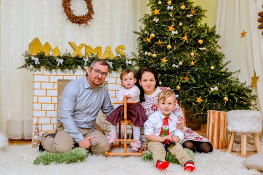 A joyful family celebrating Christmas with a decorated tree in Máréfalva, Romania.