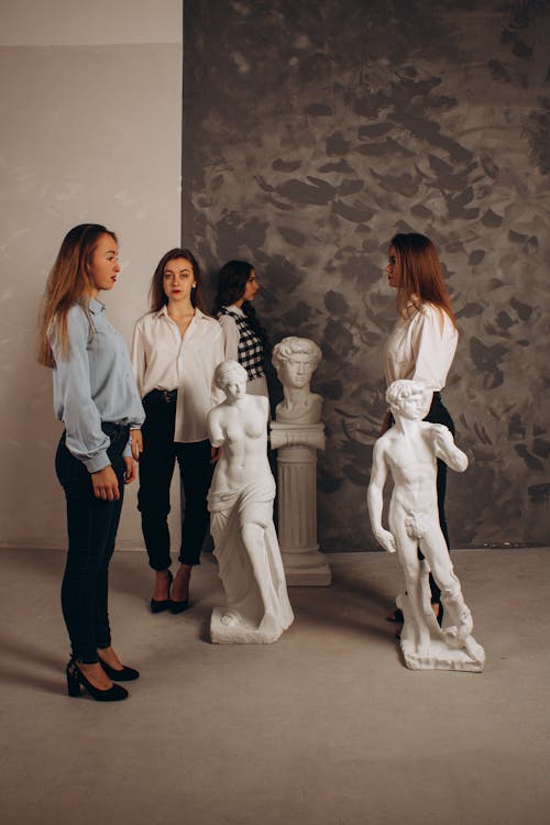 Young Women Among Sculptures in an Art Museum 