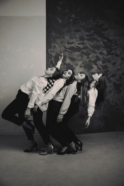 Free Four women pose artistically in a monochrome studio setting. Stock Photo