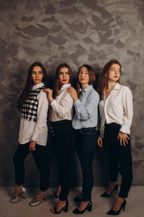 Free Four fashionable women posing in a stylish indoor studio with artistic background. Stock Photo