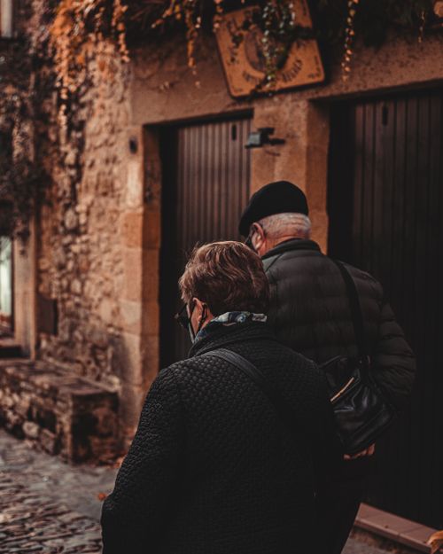 Free Senior couple walks through the charming cobblestone streets of Girona, Spain, capturing the essence of timeless companionship. Stock Photo