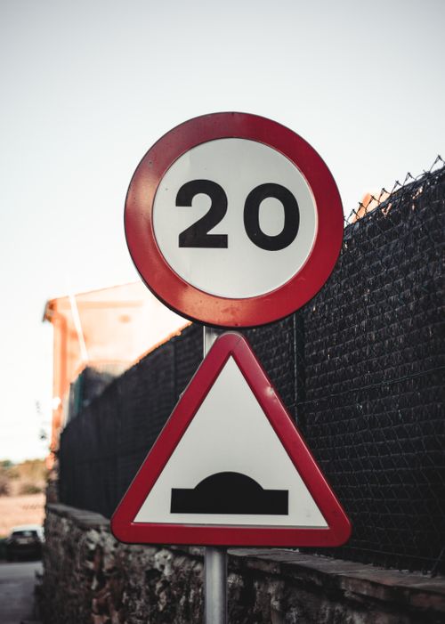 Free Traffic sign in Girona, Spain showing a 20 km/h speed limit and road bump warning. Stock Photo