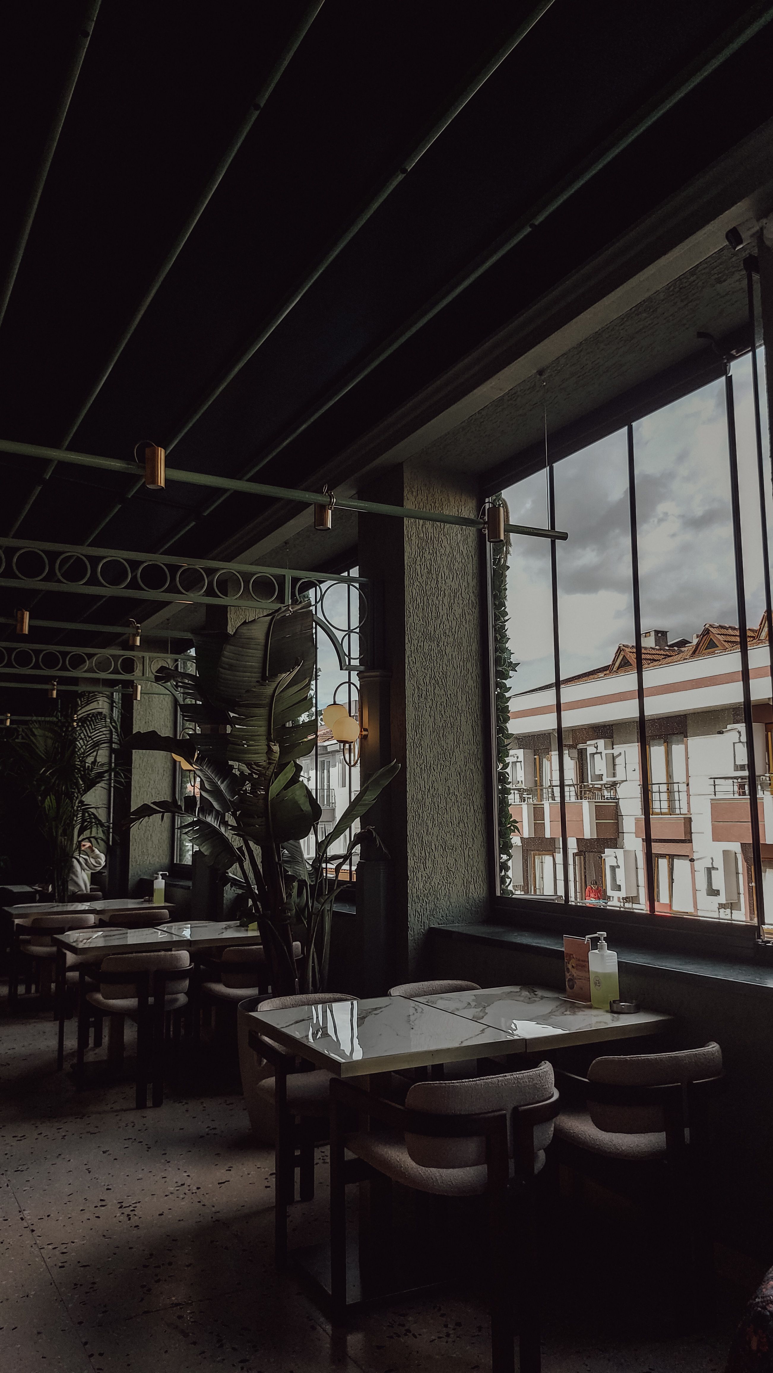 Stylish indoor restaurant scene with large window view and industrial decor.