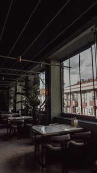 Stylish indoor restaurant scene with large window view and industrial decor.