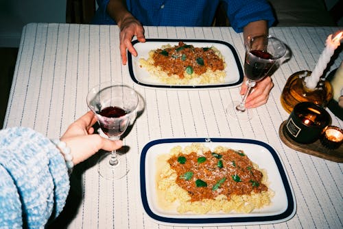 People at Table Eating Pasta and Wine