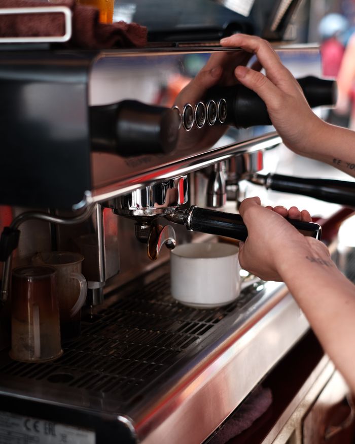 Close-up of a barista's hands at the espresso machine