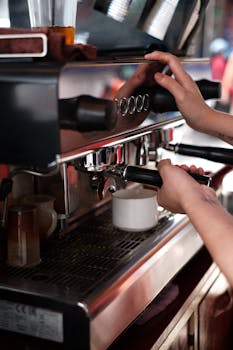 Close-up of a barista making coffee at a café using a professional espresso machine.
