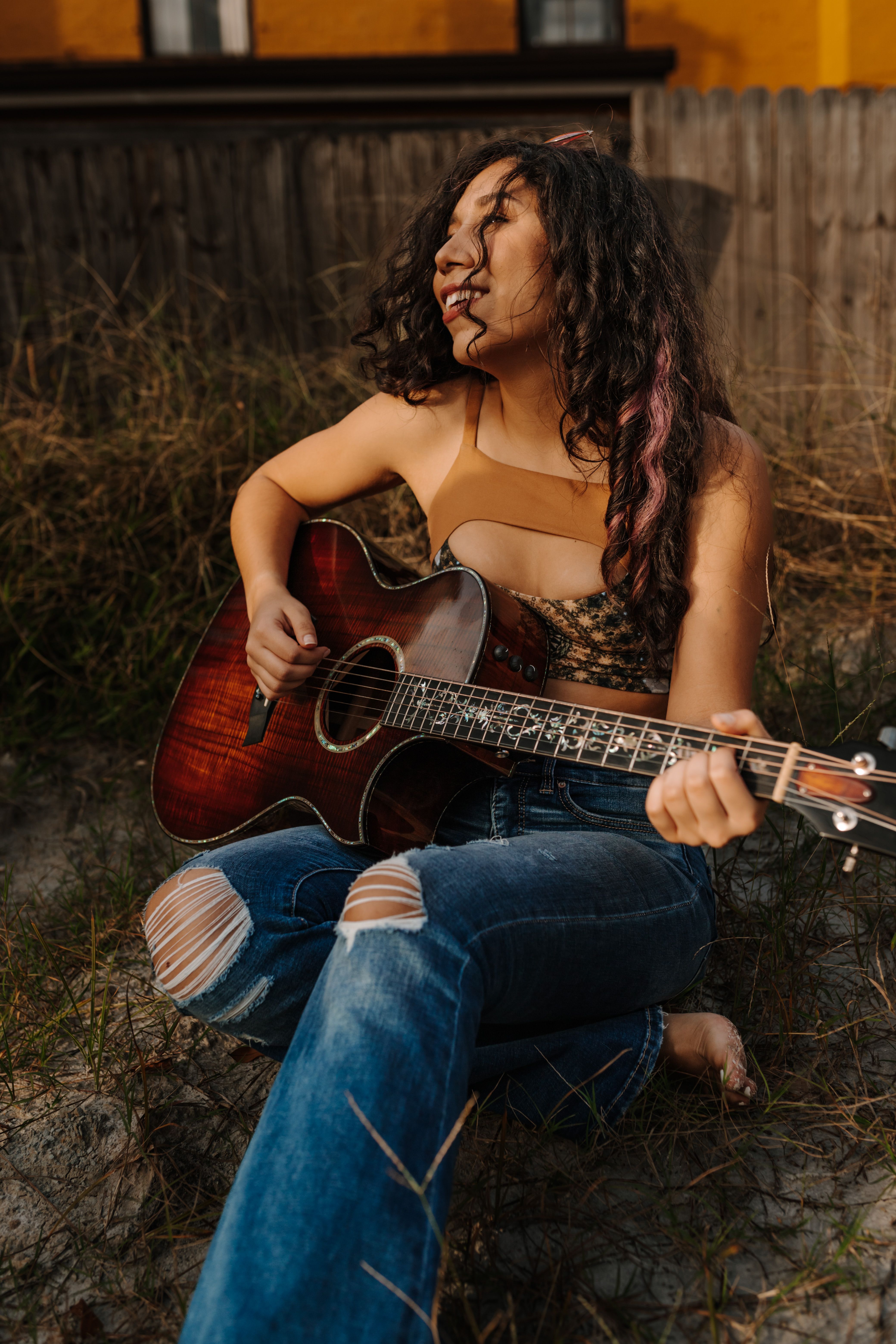 A songwriter playing acoustic guitar in golden-hour light
