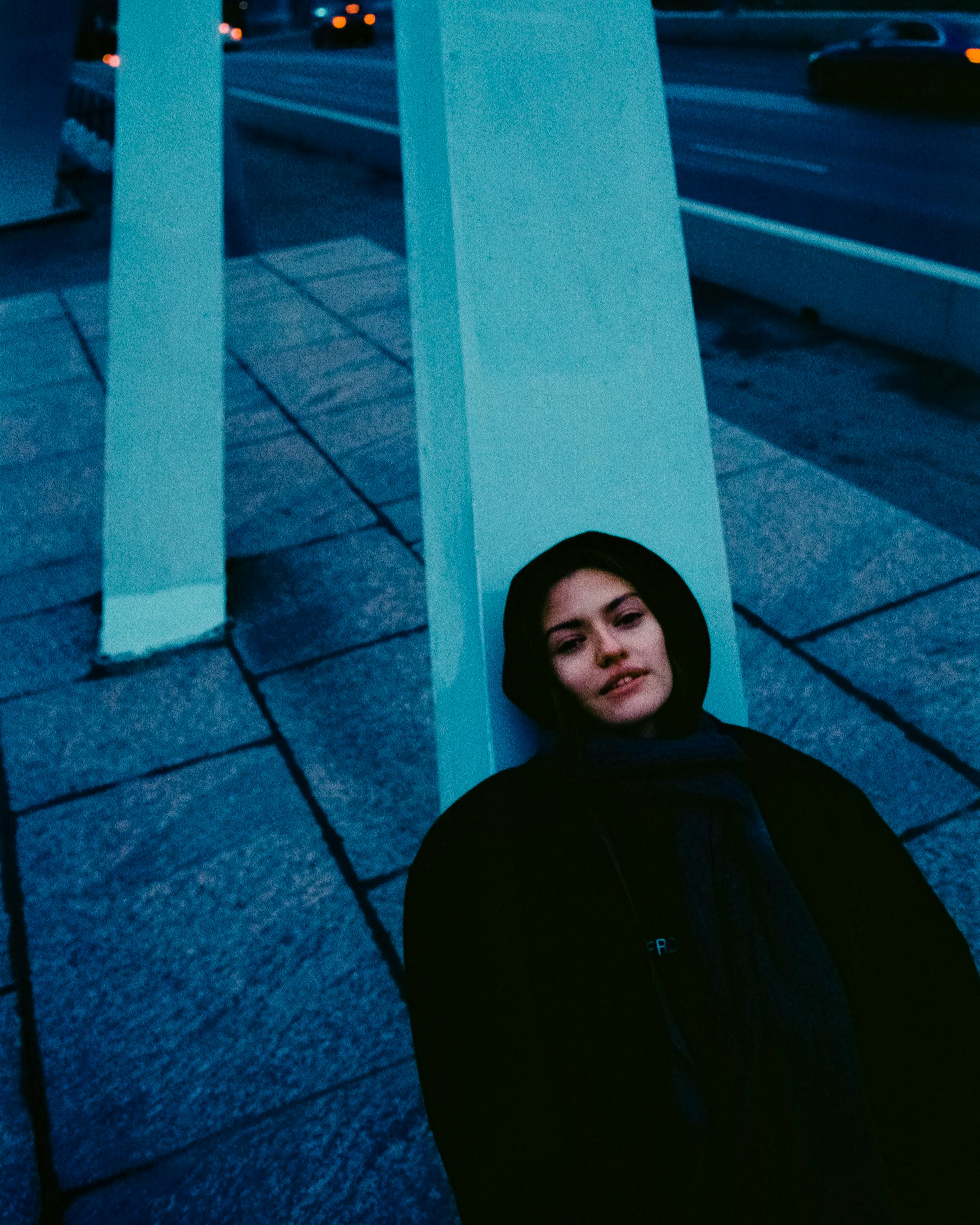 Woman resting against a pillar in a wintery urban setting in Saint Petersburg.