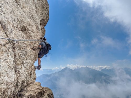 Free Adventurous rock climber scaling mountain cliff in Terlach, Italy with breathtaking view. Stock Photo