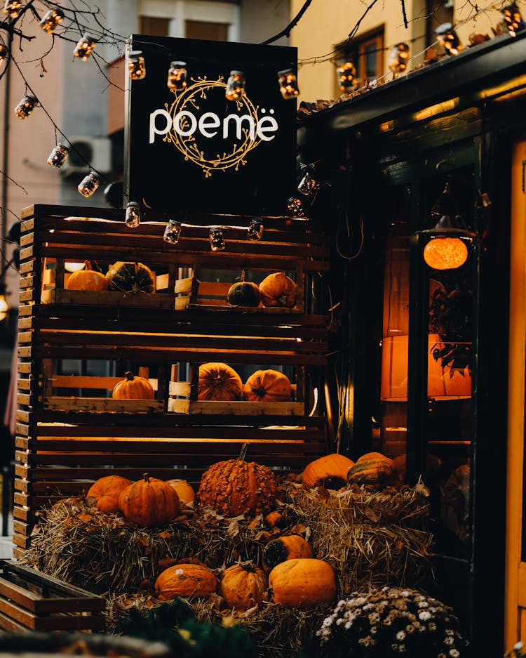 Pumpkins On Crates And Hay In Front Of A Store