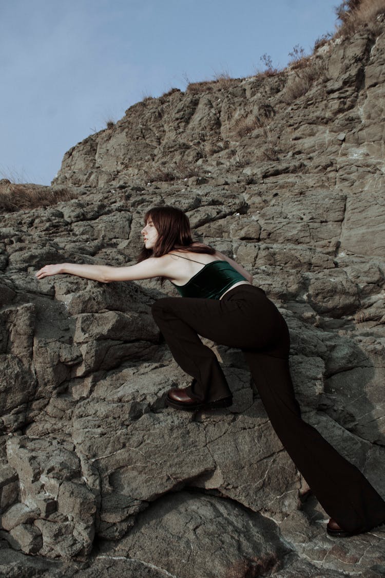 A Woman Climbing A Rocky Mountain