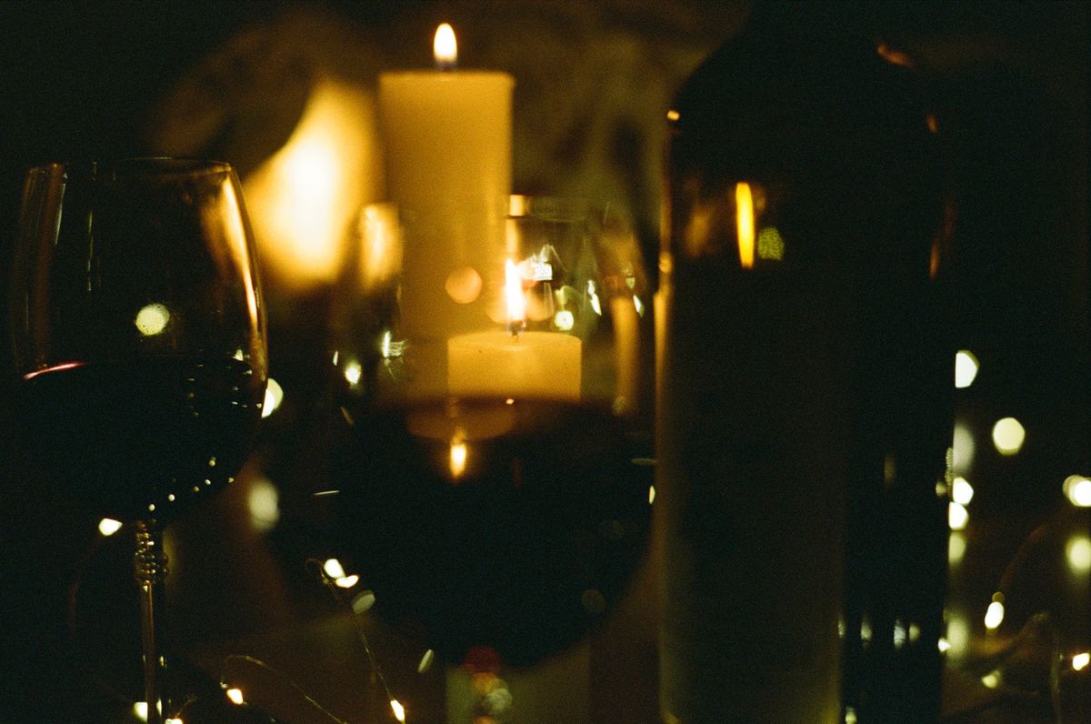 A candlelit wine tasting, glass of red and pillar candles