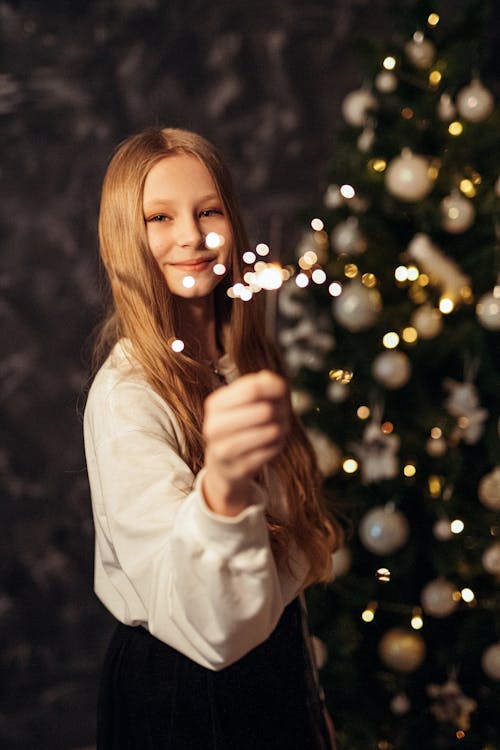 Woman Wearing White Sweater Holding a Firecracker