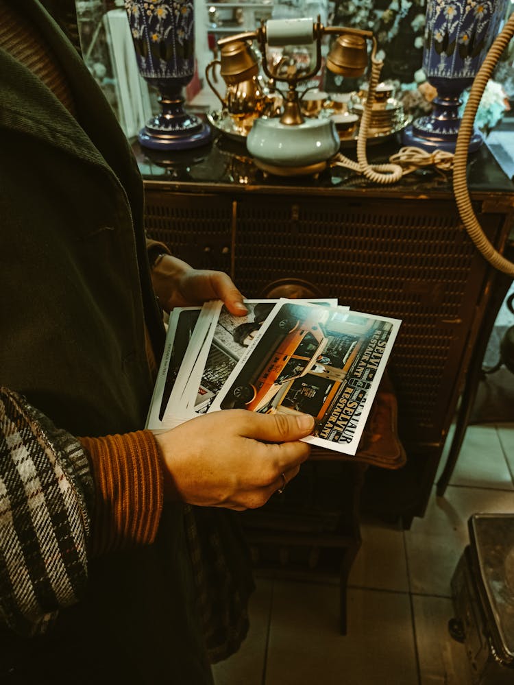 A Close-Up Shot Of A Person Holding Photos