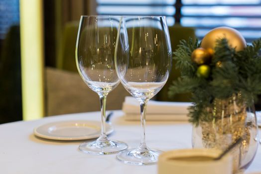 Sophisticated dining table setup with wine glasses and festive Christmas decorations offering elegance and warmth.