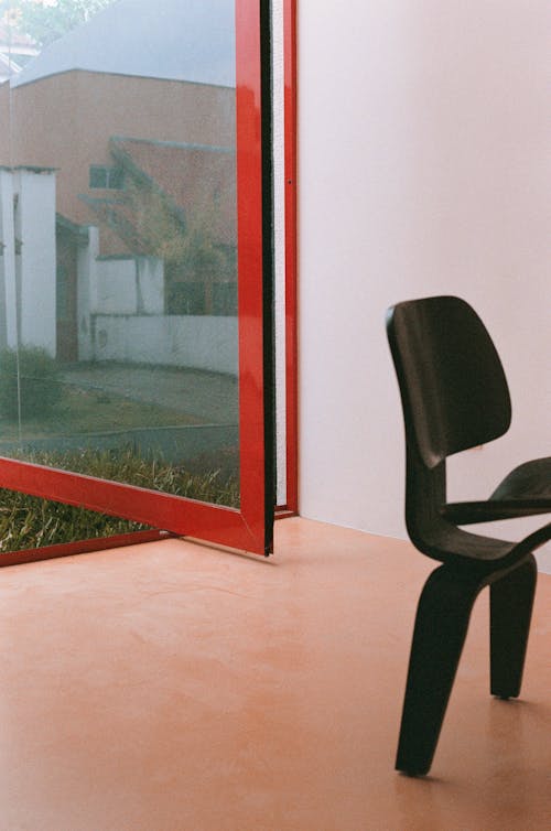 Darmowe zdjęcie z galerii z czarne krzesło, czerwona ramka, drewniana podłoga