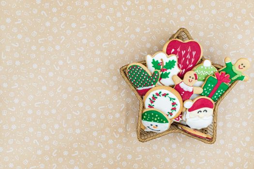 Colorful Christmas cookies arranged in a star basket on festive patterned paper.