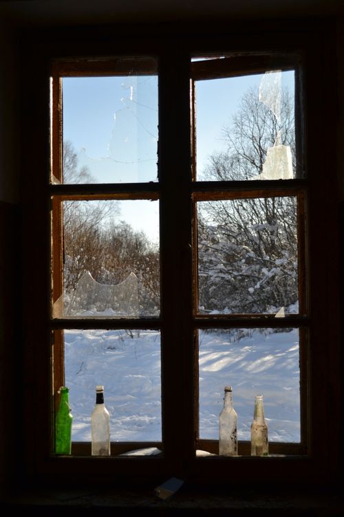Free Broken window with bottles, snowy landscape and leafless trees in Estonia, winter setting. Stock Photo