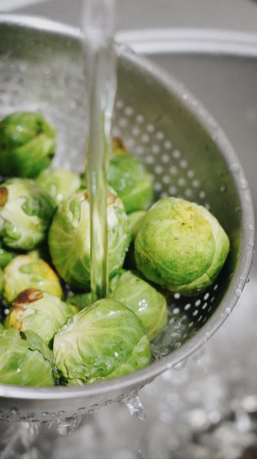 Free Brussel Sprouts Being Washed on a Strainer Stock Photo