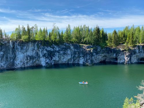 Free Tranquil boat ride through Ruskeala's stunning marble cliffs and lush greenery. Stock Photo