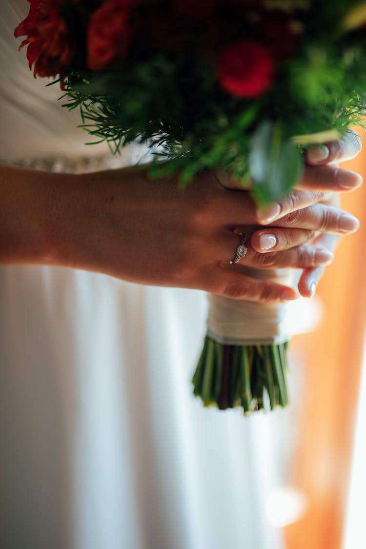 Unrecognizable Female Hands Holding Wedding Bouquet Of Red Flowers