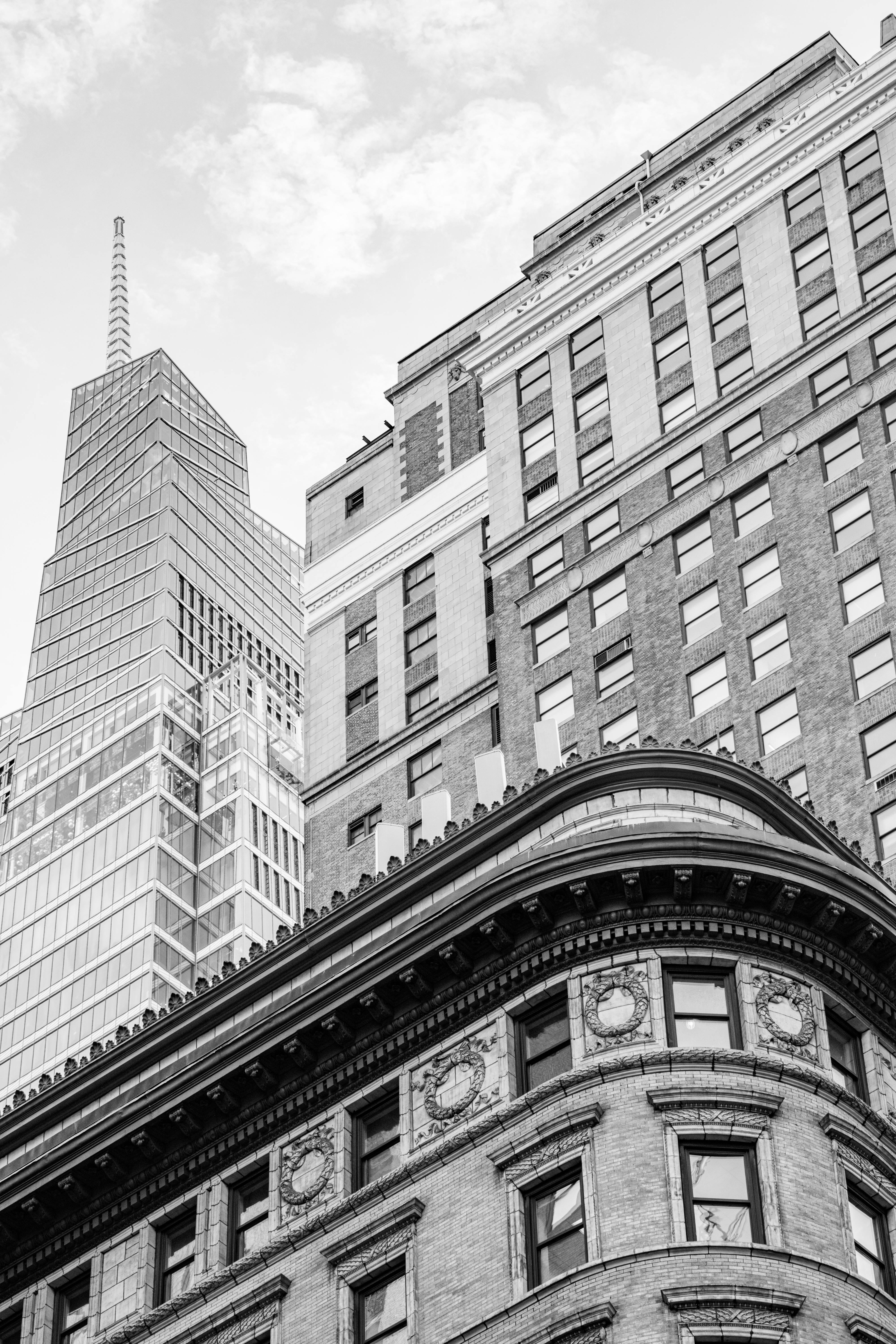 Black and white cityscape of New York City's iconic architecture showcasing diverse styles and dramatic perspectives.