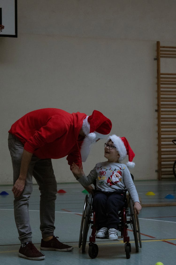 Man Talking To A Boy In A Wheelchair 