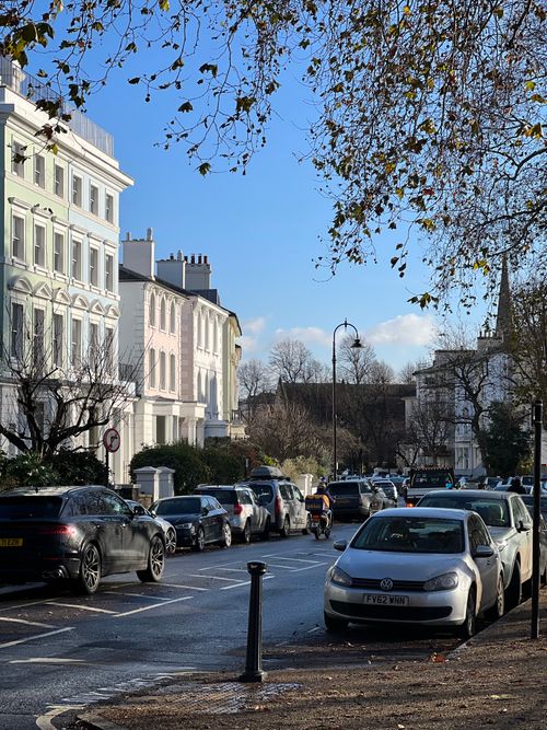 Free Peaceful urban scene with parked cars and classic architecture on a bright day. Stock Photo