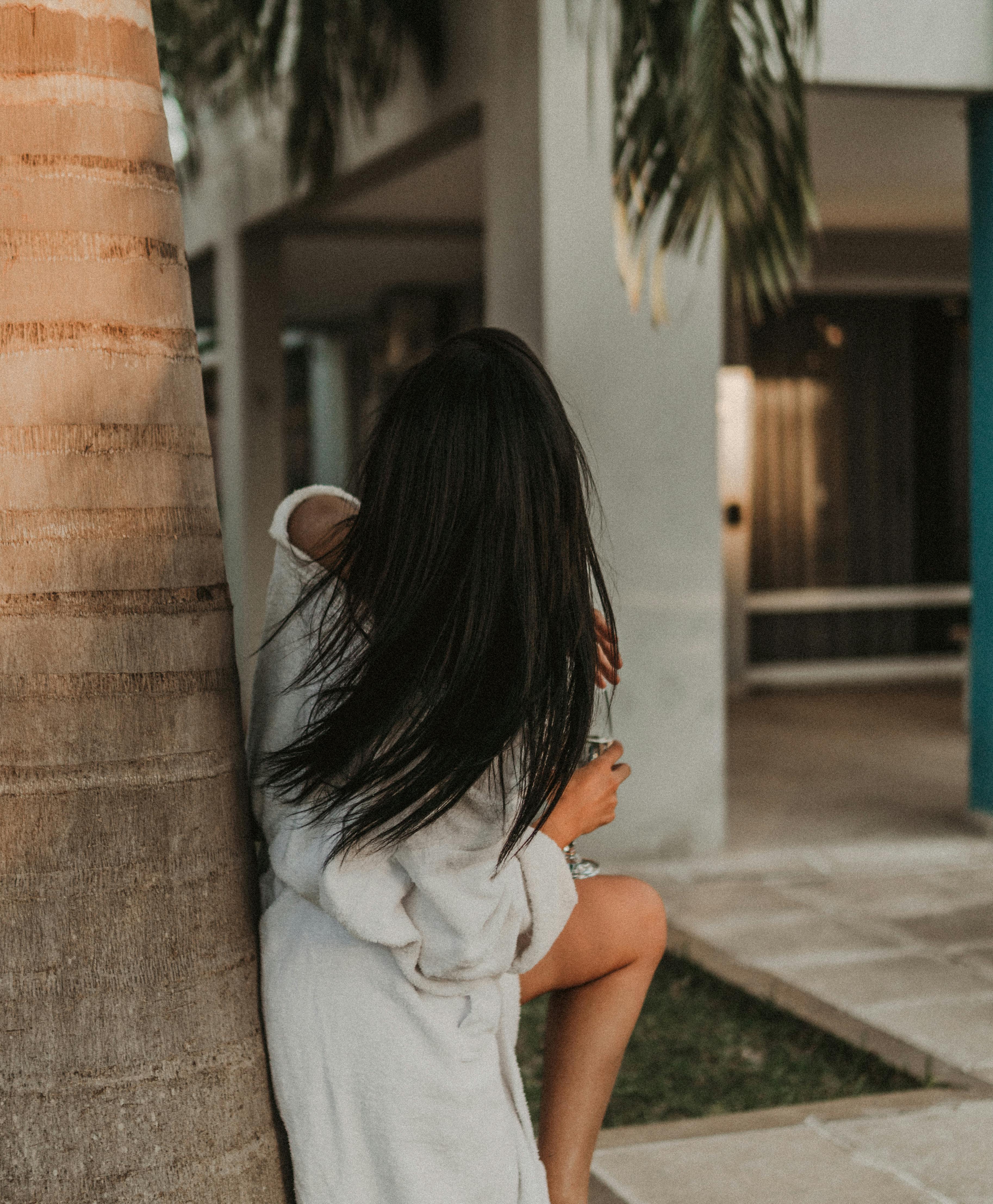 Woman in Bathrobe Leaning on a Palm Tree · Free Stock Photo
