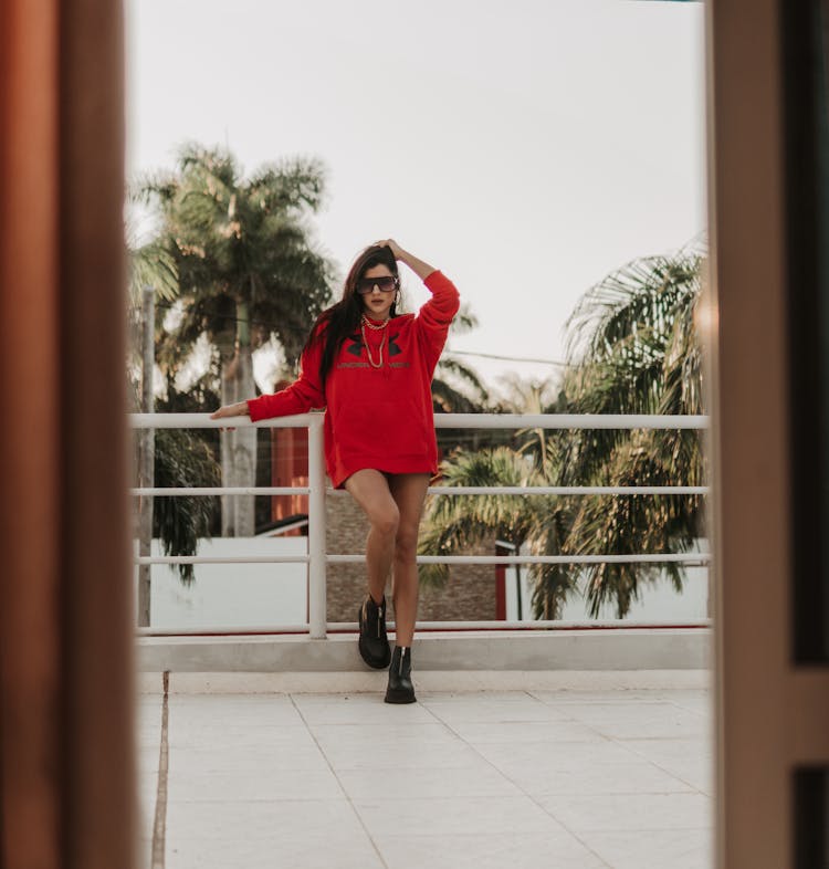 Woman In Red Hoodie Leaning On Railing