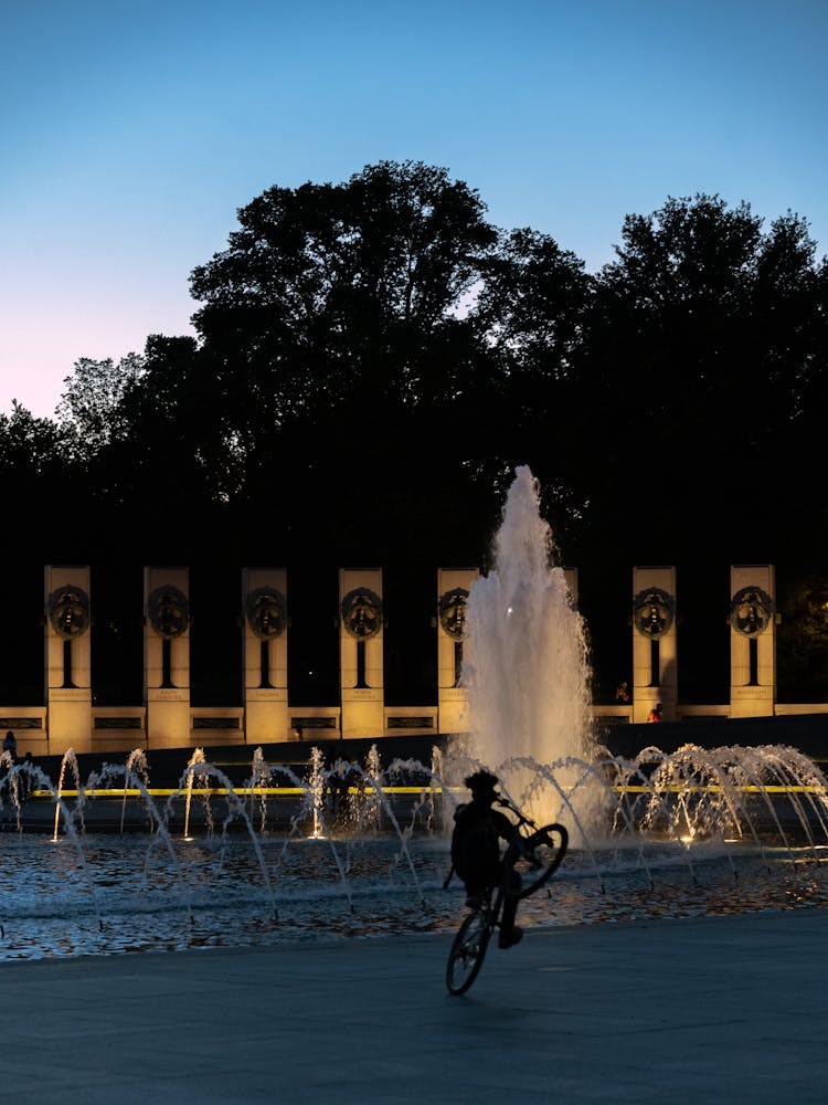 A Silhouette Of A Person Doing A Bike Wheelie