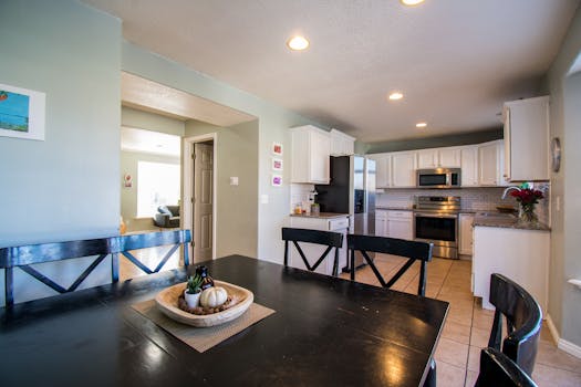 Spacious kitchen and dining area with modern design and elegant decor lighting.