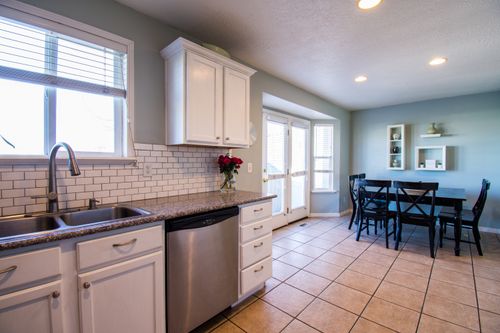 Free Spacious kitchen and dining area with natural light and modern decor. Stock Photo