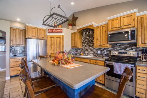 Free Warm and inviting rustic kitchen featuring wooden cabinets and modern appliances. Stock Photo