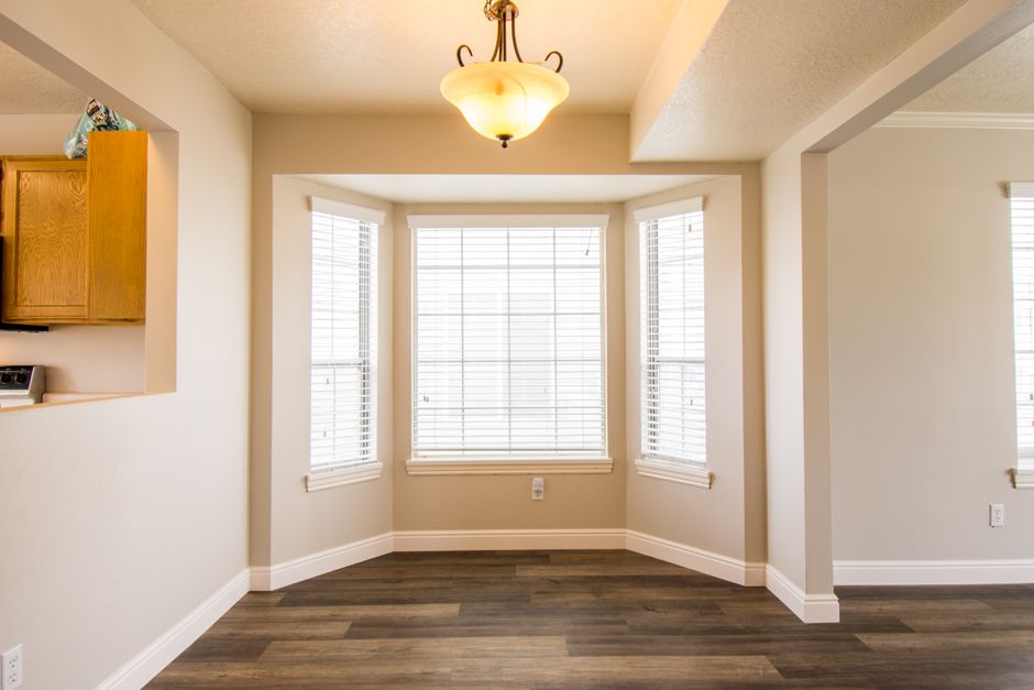 A bay window with a deep wood sill used as a display shelf