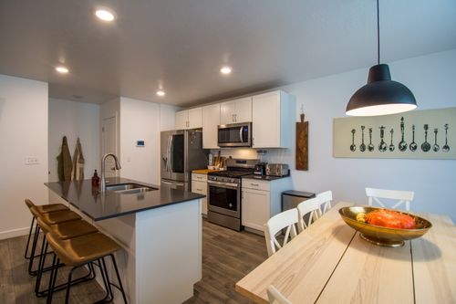 Free Contemporary kitchen interior with island, dining table, and stylish decor. Stock Photo