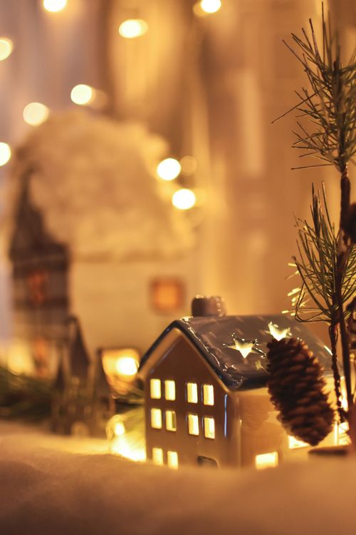 Free Charming Christmas village scene with cozy illuminated houses and pine branches, evoking festive warmth. Stock Photo