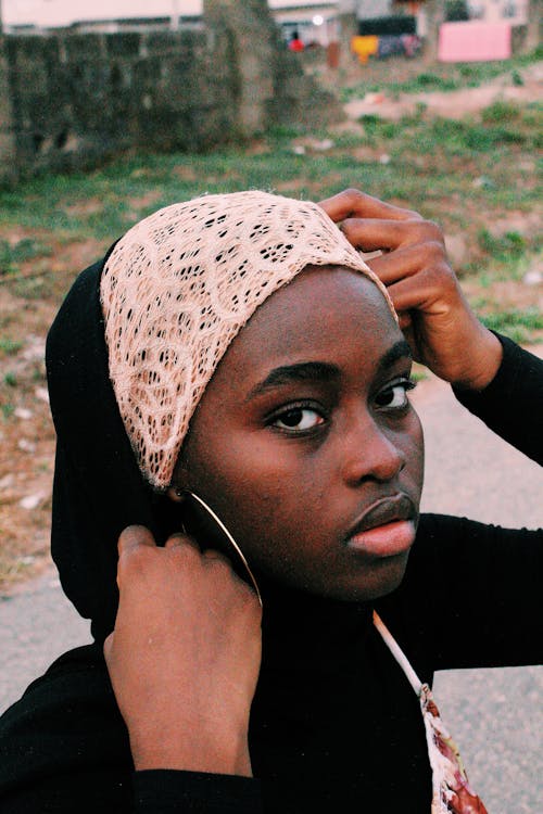 Woman in Lace Headscarf and Black Long Sleeves Seriously Looking at the Camera