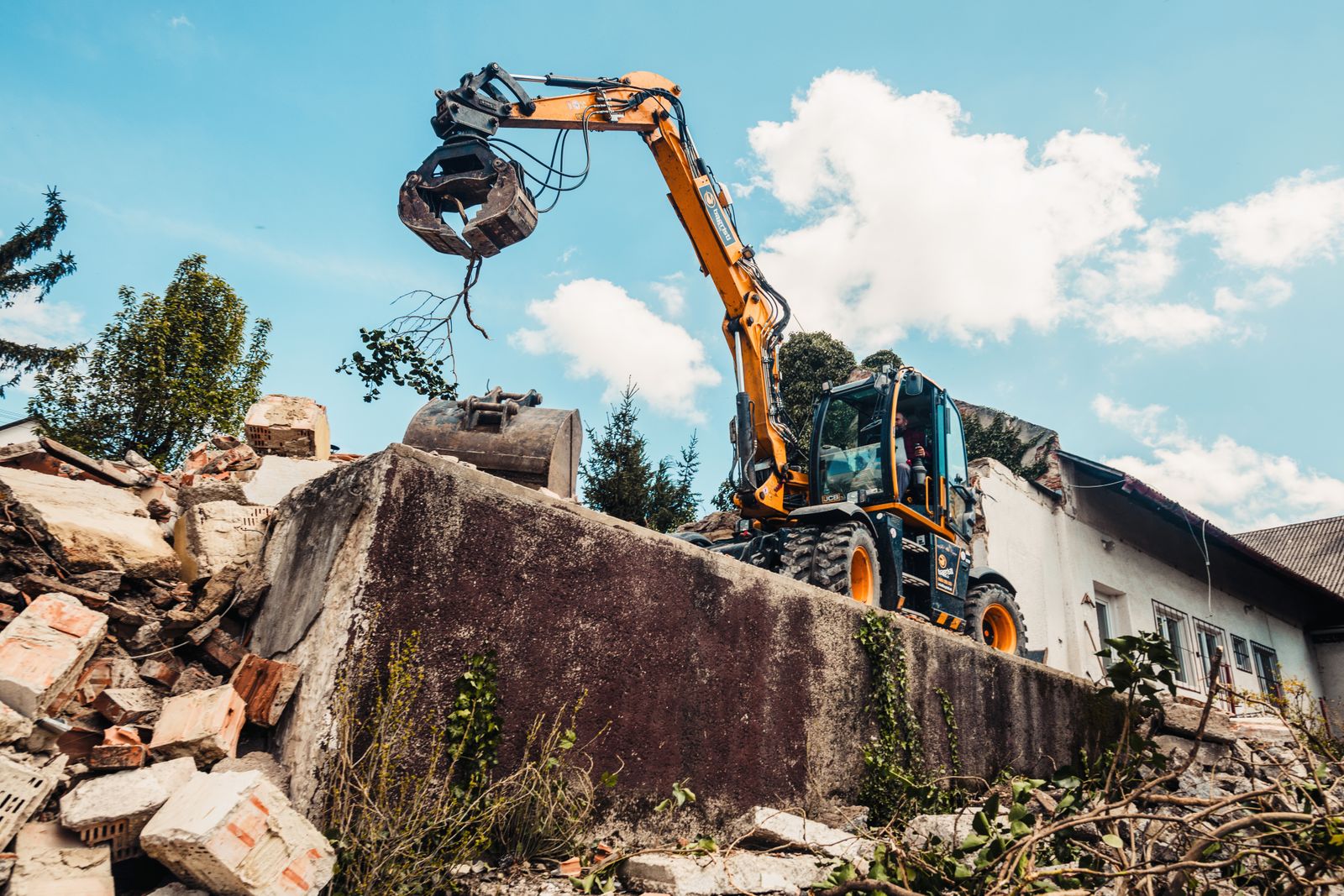 Excavator with a grab arm on a demolition site