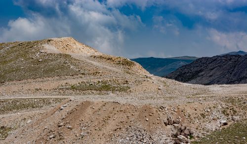 Free A rugged mountain landscape with cloudy blue skies and rocky terrain showcasing natural beauty. Stock Photo